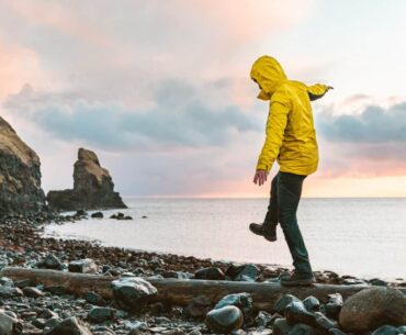 Man hanging in the balance over a log at seaside in Scotland