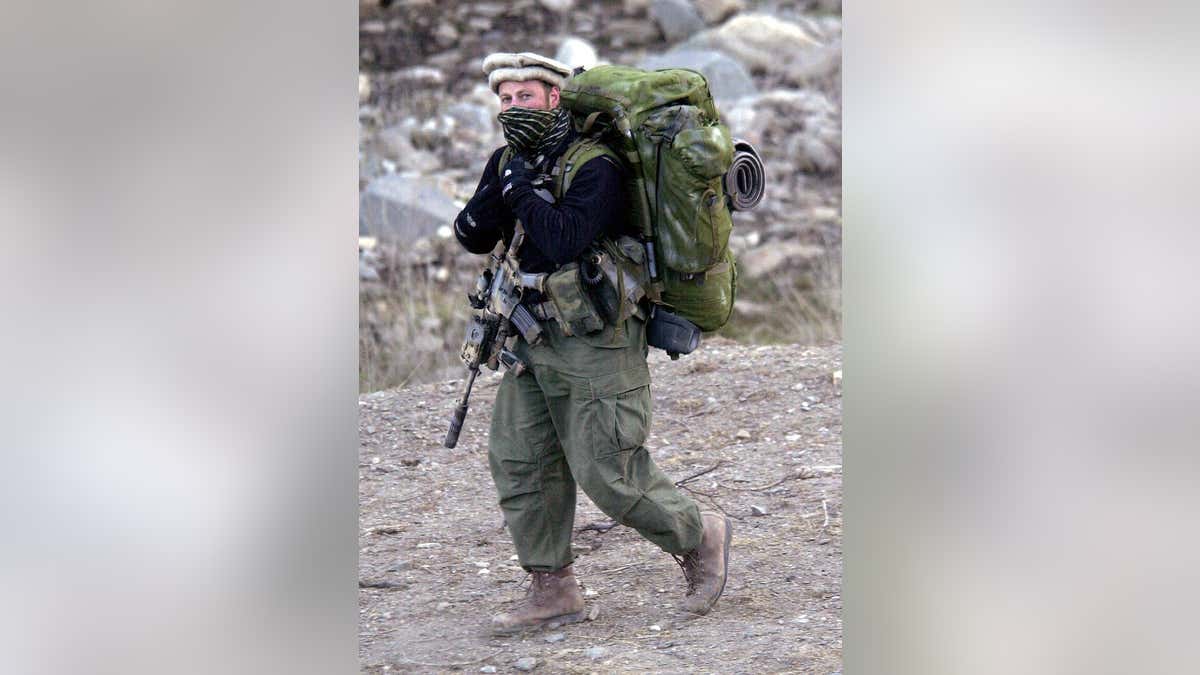 An unidentified western commando walking with combat pack carrying US assault rifle at Tora Bora base