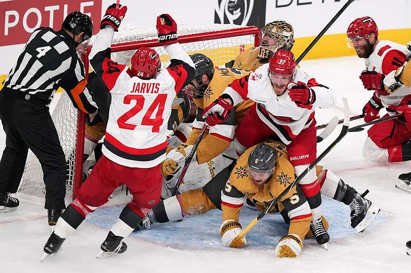 Carolina Hurricanes right wing Andrei Svechnikov (37) celebrates his goal with right wing Seth Jarvis (24) and center Jordan Staal (11) as he steps over Vegas Golden Knights defenseman Jeremy Lauzon (5) during the third period in Game 3 of the NHL hockey Stanley Cup Final series Saturday, June 6, 2026, in Las Vegas. (AP Photo/Candice Ward)