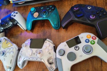 An angled photo of six pro controllers on a gaming desk