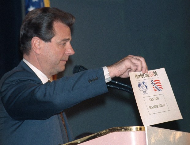 U.S. Soccer president Alan Rothenberg holds up a card reading "Chicago Soldier Field," at a March 23, 1992, news conference in New York revealing the nine sites for the 1994 FIFA World Cup. (AP Photo/Osamu Honda)