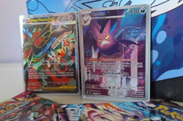 A Golbat and Mega Floette ex card against a Chaos Rising Elite Trainer Box, with boosters visible in the forground