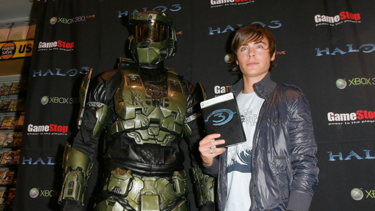 Actor Zac Efron posing with Master Chief character at a video game event in Universal City