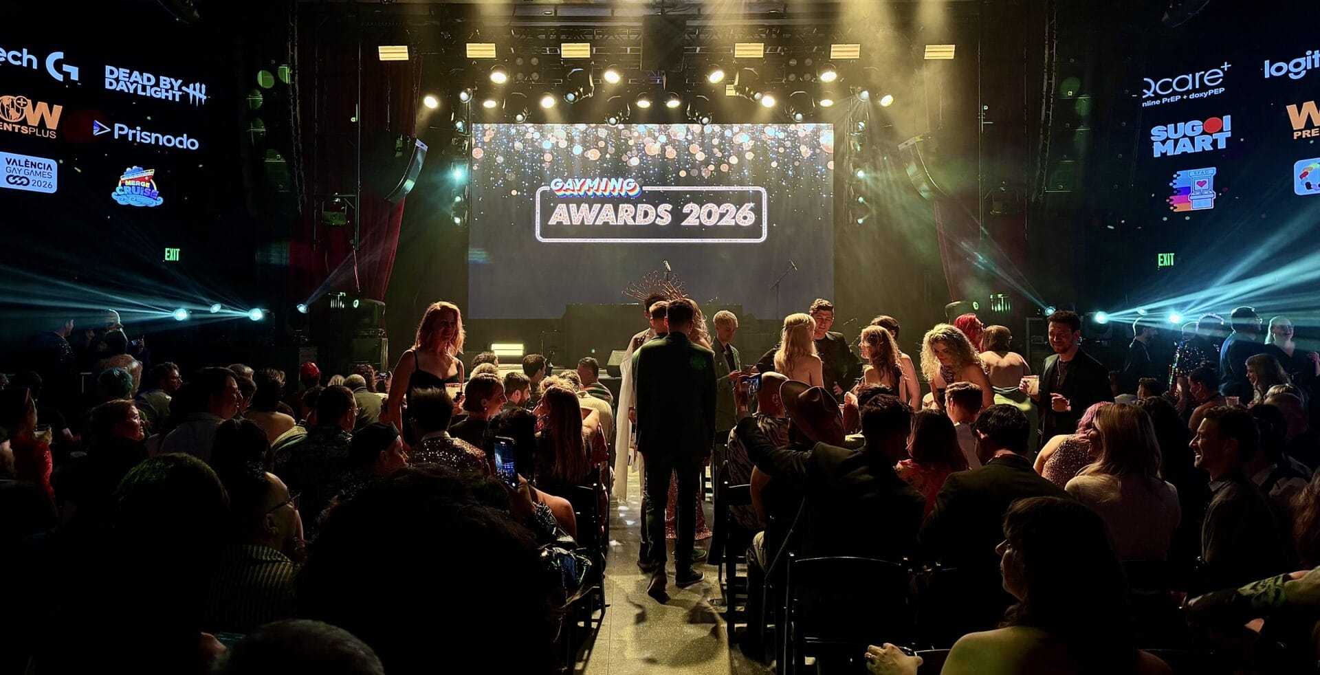 IMG_1692 1 | GLAAD Crowd of people gathered at an awards ceremony in a dim venue, facing a large stage with bright lights and a screen reading 'GAYMING AWARDS 2026'.
