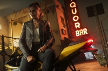 A woman in a leather jacket leans against a motorcycle outside a liquor store at night