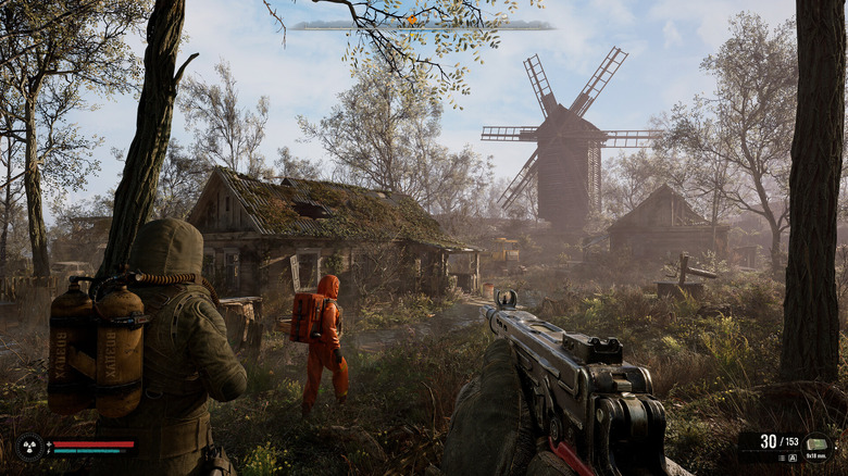A group of soldiers approach an abandoned farm and windmill in S.T.A.L.K.E.R. 2: Heart of Chornobyl