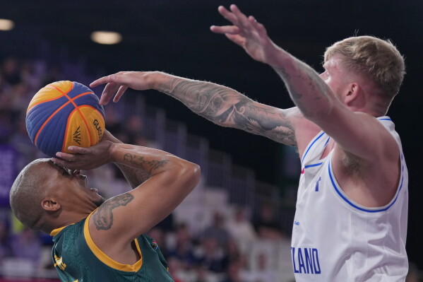 South Africa's Simanga Mbhele, left, attempts to throw a basket as Scotland's Tyler Baines goes to block during their 3x3 basketball match between South Africa and Scotland at the Commonwealth Games in Glasgow, Scotland, Saturday, July 25, 2026. (AP Photo/Alastair Grant)