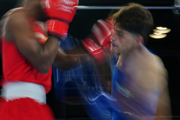 Pakistan's Afzal Khan, right, and Jovanie Bouzin of Seychelles, compete during the Men's 65kg round of 32 boxing bout during the Commonwealth Games in Glasgow, Scotland, Friday, July 24, 2026. (AP Photo/Kin Cheung)