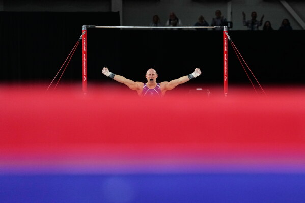 Scotland's Hamish Carter celebrates as he competes at the Horizontal bar during men's team final and individual qualification of Artistic Gymnastics at the Commonwealth Games in Glasgow, Scotland, Friday, July 24, 2026. (AP Photo/Manish Swarup)