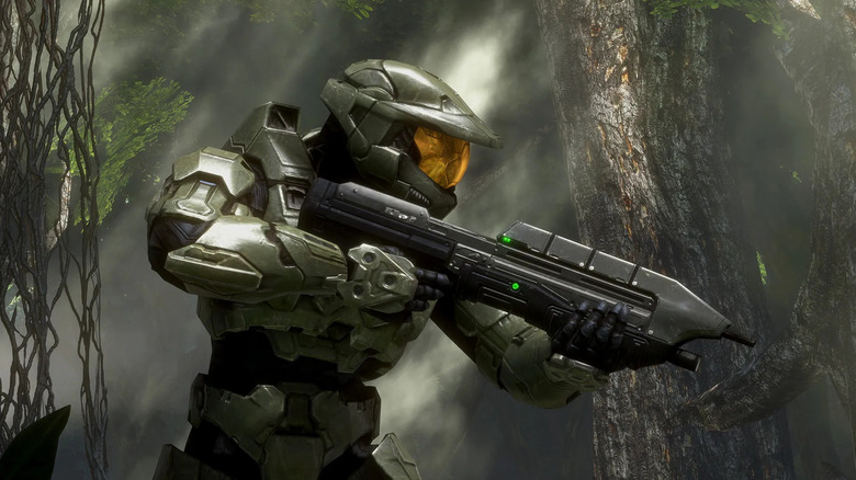 Master Chief walks through a jungle with an assault rifle in Halo 3