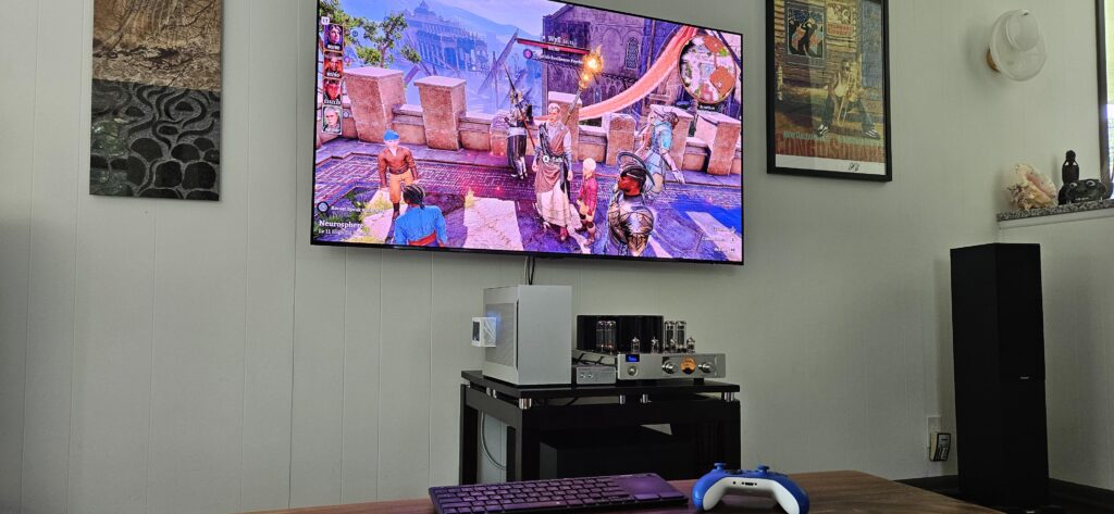 Living room battlestation — SFF PC into a tube amp, on a 65" OLED. Gaming and hifi in one.