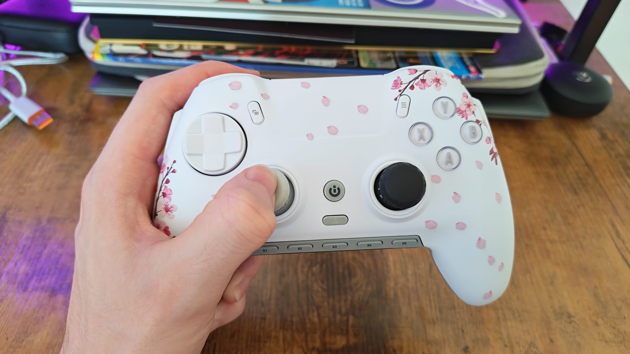 A reviewer holding the Scuf Envision Pro in one hand