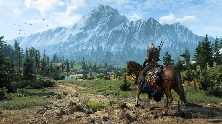 Geralt of Rivia rides a horse by a mountain range in The Witcher 3: Wild Hunt