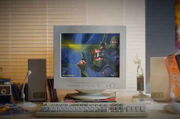 Counter-Strike 2 release trailer screenshot showing an old-style white desktop PC running the Counter-Strike menu atop a wooden desk