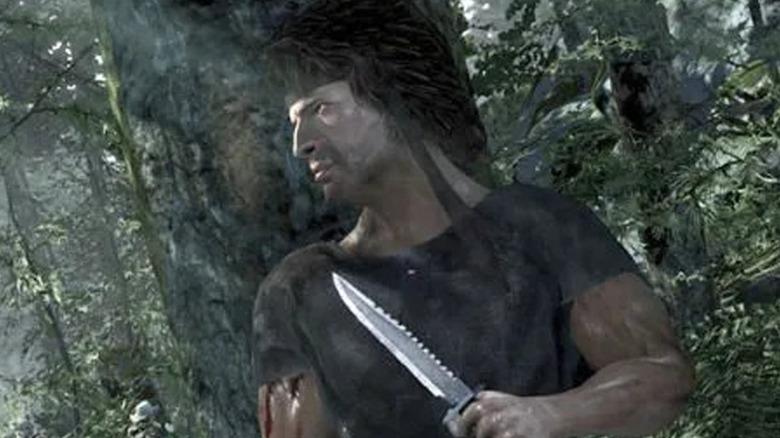 A poorly rendered John Rambo model hides behind a tree with his knife drawn in Rambo: The Video Game