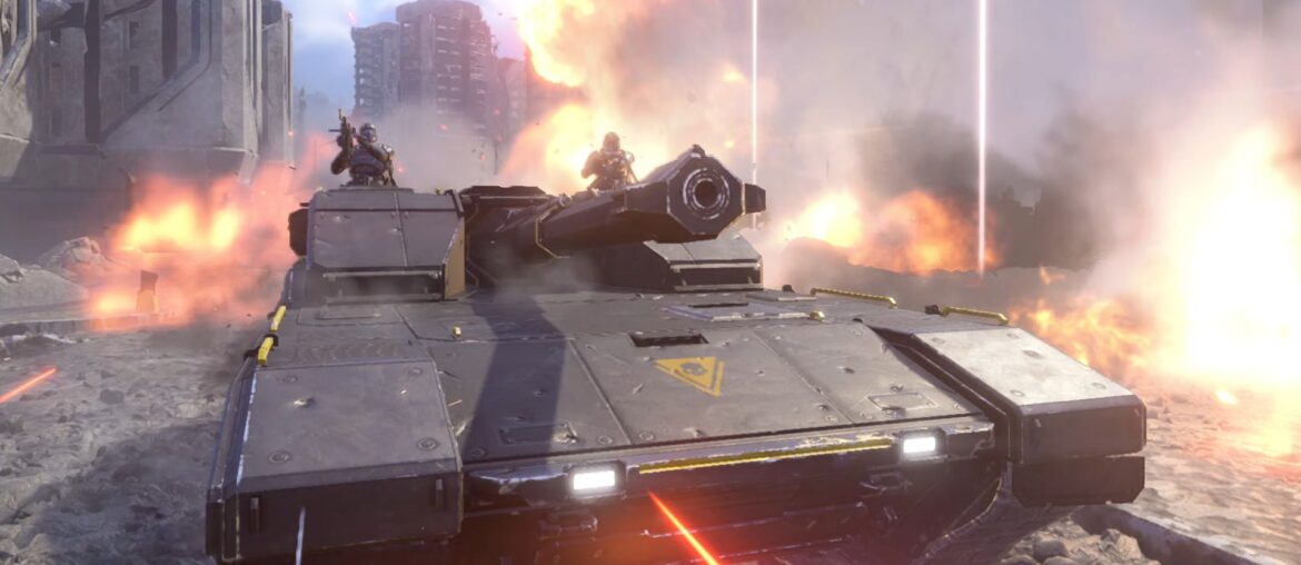 A Bastion tank rolling through a city street surrounded by explosions in Helldivers 2.